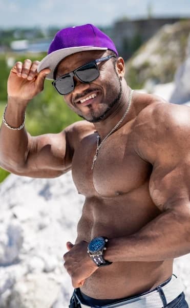 A gay muscled man on the beach browsing gay chat online