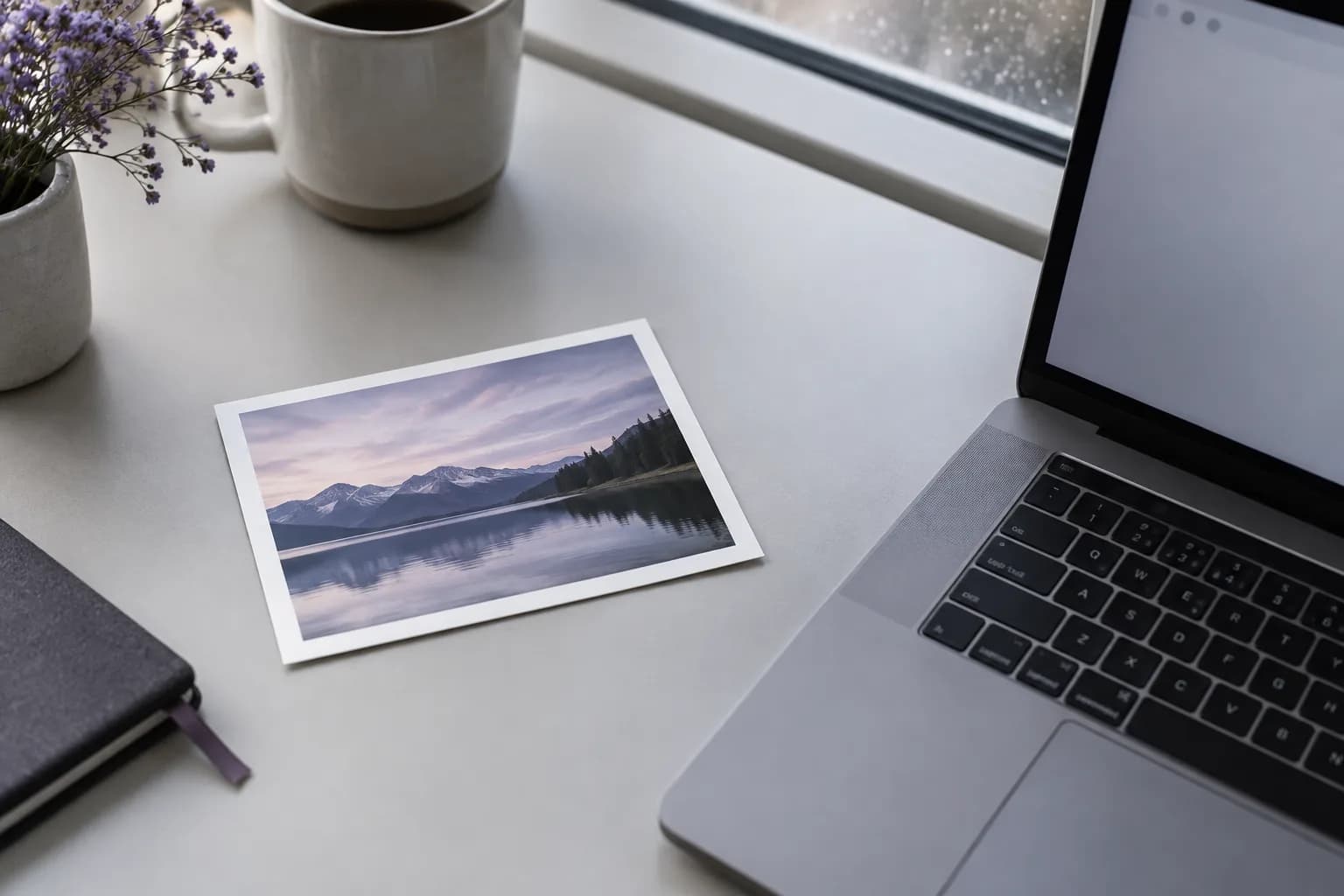 A printed landscape photo beside a laptop, representing a portable Murmelt identity backup